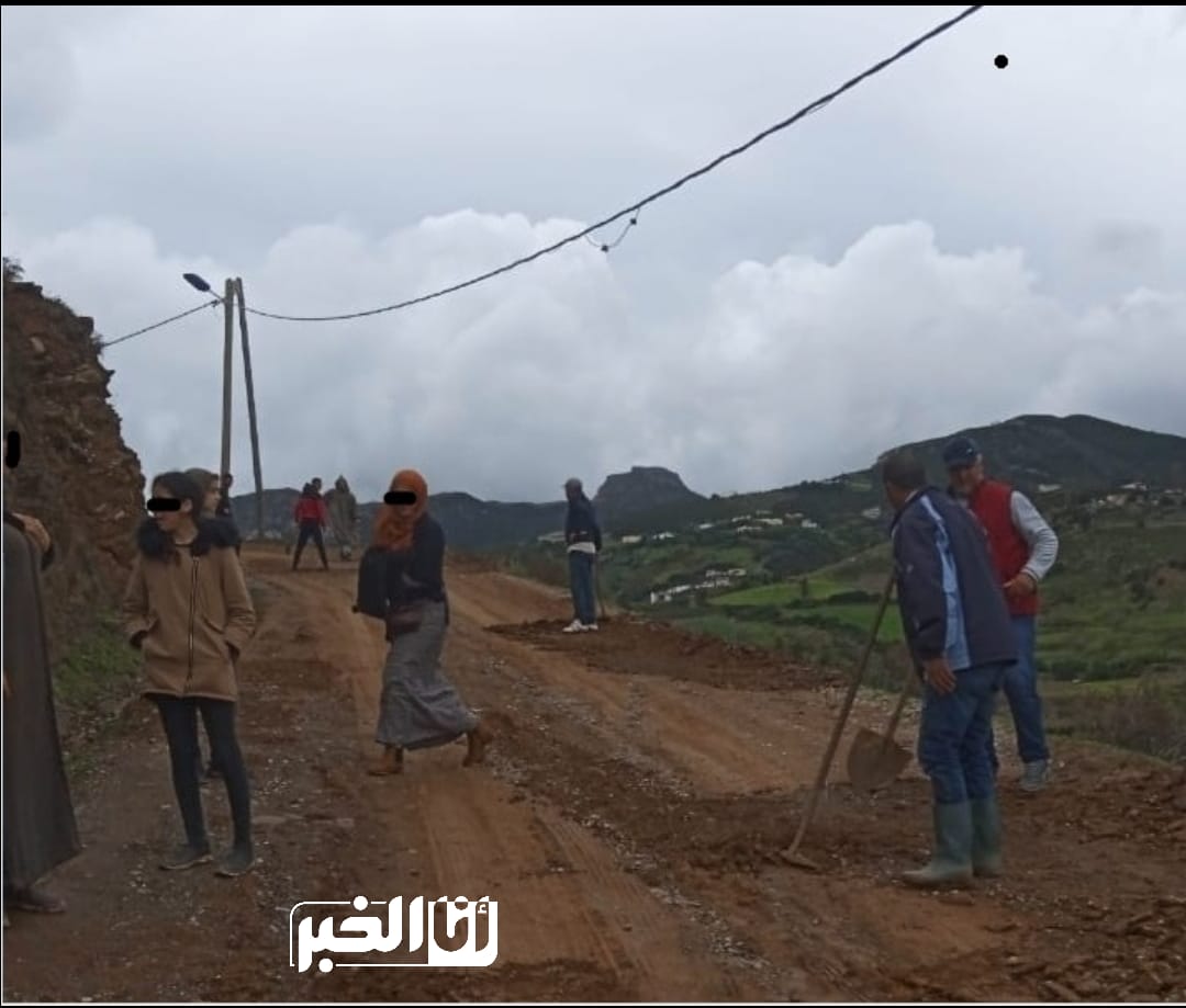 جانب من سكان بني مزالة وهم يحاولون اصلاح الطريق