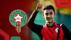 أيوب أوفقير بخلفية شعار الجامعة الملكية