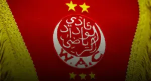 شعار نادي الوداد الرياضي المغربي (WAC) مطرز باللونين الأحمر والأبيض مع النجوم، كصورة بارزة لخبر تعيين مراد بنشريفة مدرباً للفريق