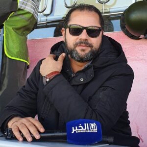 الصورة الشخصية لأحمد الحبوسي ممسكا بمايكروفون يحمل شعار جريدة أنا الخبر
